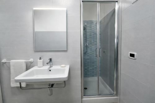 a white bathroom with a sink and a shower at Casa Sveva al Cavo in Cavo