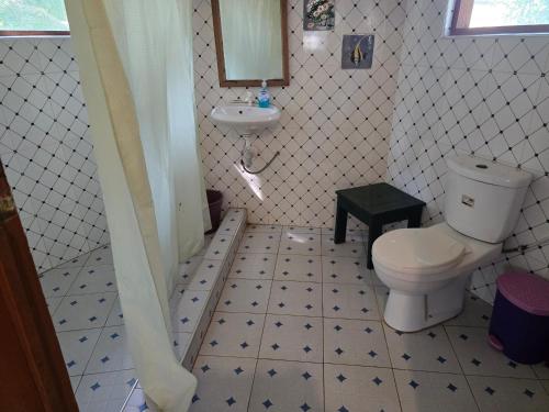 łazienka z toaletą i umywalką w obiekcie Hideout Lodge w mieście Butre