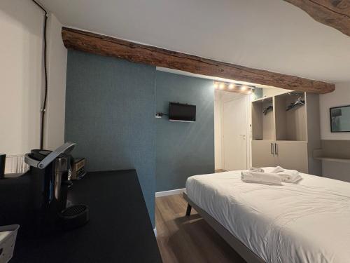 a bedroom with a white bed and a blue wall at Cozy Apartments and Rooms in Caselle di Sommacampagna