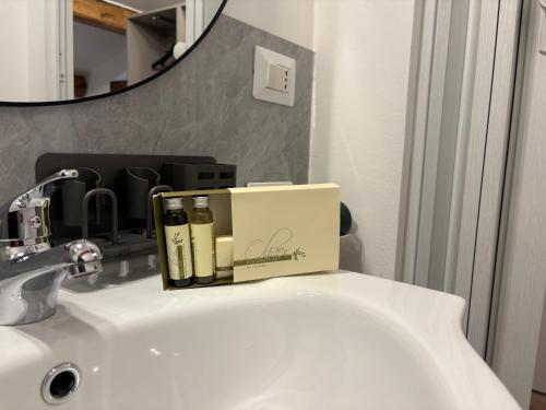 a box sitting on top of a bathroom sink at Cozy Apartments and Rooms in Caselle di Sommacampagna