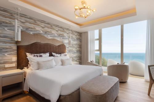 a bedroom with a large bed and a large window at Views Boutique Hotel & Spa in Wilderness