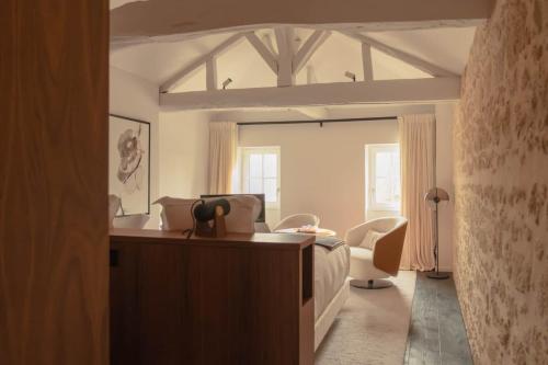 a bedroom with a bed and a desk in a room at Château Fonroque La Suite in Saint-Émilion