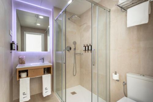 a bathroom with a shower and a toilet and a sink at Petit Palace Vargas in Seville