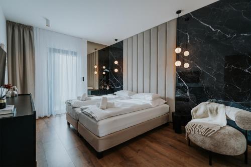 a large bedroom with a large bed and a chair at Villa Slowave in Balatonalmádi