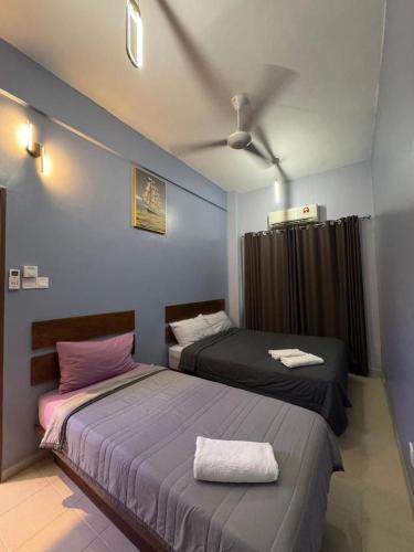 two beds sitting next to each other in a bedroom at Pangkor L30 88 Corner villa House in Pangkor
