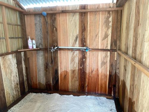 a wooden barn with a shower in it at Isiie Homestay in Merpati
