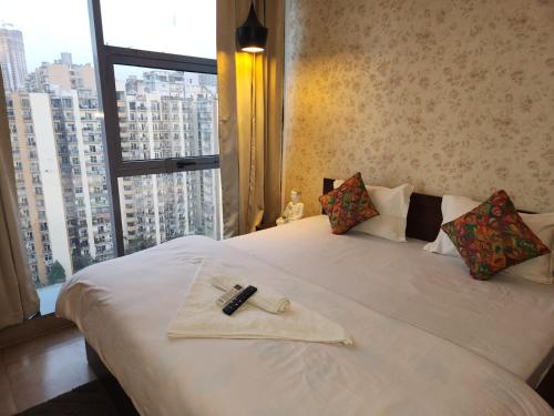 a bedroom with a white bed with a large window at Tranquil Homes in Noida