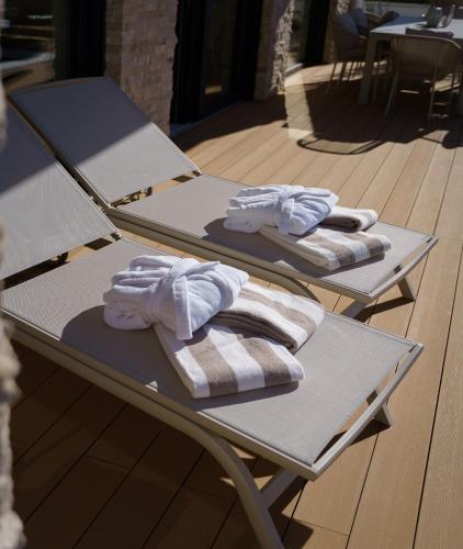 two lounge chairs with towels on them on a patio at Villa Slowave in Balatonalmádi