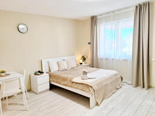 a bedroom with a bed and a clock on the wall at Dunes Trail 4 in Melnragė
