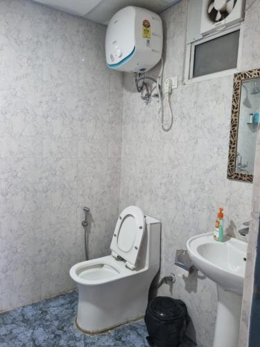 a bathroom with a toilet and a sink at Tranquil Homes in Noida