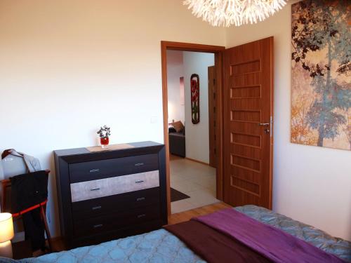 ein Schlafzimmer mit einem Bett, einer Kommode und einer Tür in der Unterkunft Apartament Aga Świnoujście in Świnoujście