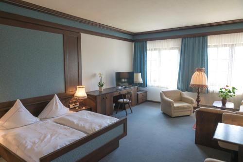 a hotel room with a bed and a desk and chair at Landhaus Deuber in Weismain