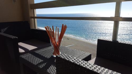 um vaso de vidro sentado numa mesa perto da praia em Apartamentos Chinasolymar em Almuñécar