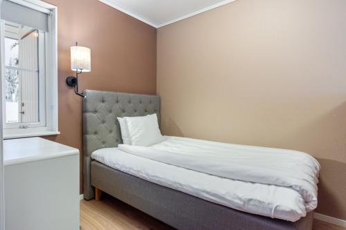 a bedroom with a bed and a window at Simloc Hotel Öberget in Arjeplog