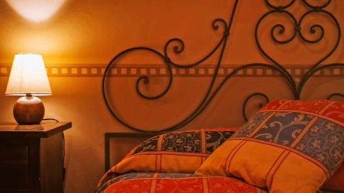 a bedroom with a bed with a headboard and a lamp at Agriturismo Parco Fiorito in Cortona