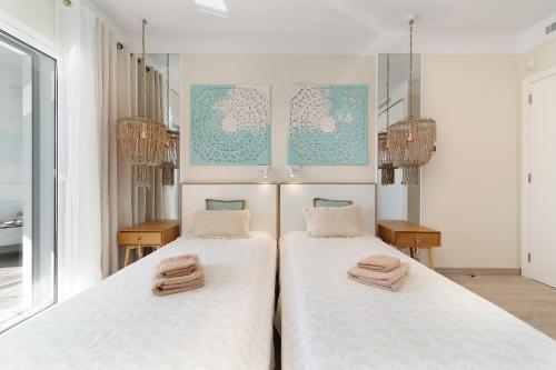 a bedroom with two beds with towels on them at Apartment Belharucas in Albufeira