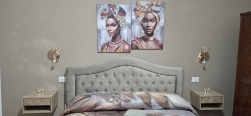 a bedroom with two portraits of women on the wall at Stella Bianca in Giulianova