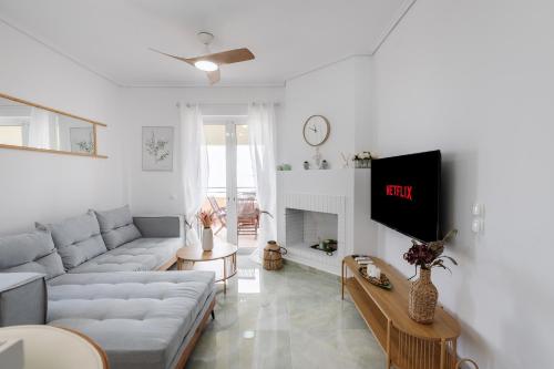 a living room with a couch and a tv at CorfuLevante Sea View in Barbati