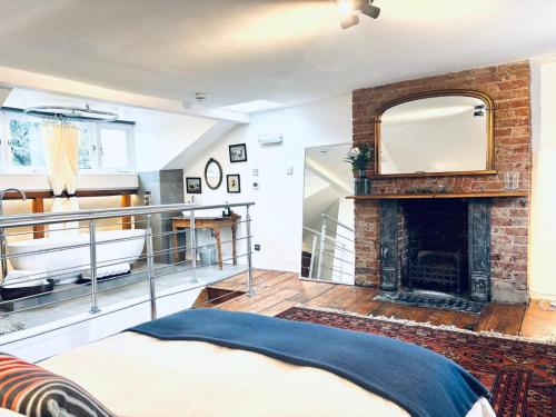 a living room with a fireplace and a mirror at Central Victorian House in London