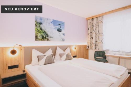 a bedroom with a large white bed and a chair at Pension Monika, Summercard included in Kaprun
