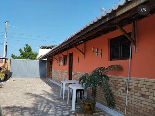 a house with a table and a plant in front of it at Chalés de Tibau in Tibau