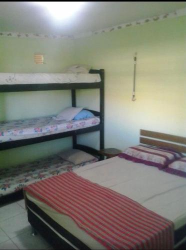 a room with two bunk beds and a bed at Chalés de Tibau in Tibau