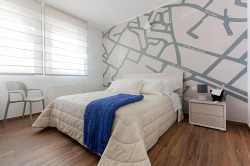 a bedroom with a bed with a blue blanket on it at Residenza 1955 in Matera