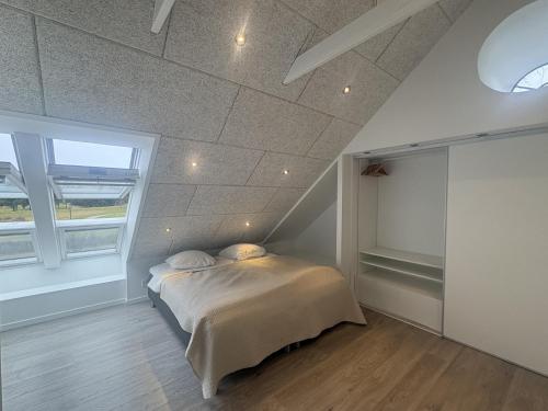 a bedroom with a bed and a large window at Tollundgaard Golf Park & Apartments in Funder Kirkeby