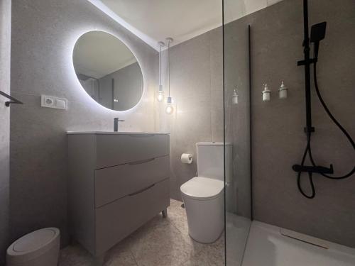a bathroom with a toilet and a mirror at Araya Apartments in Benidorm