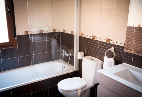 a bathroom with a toilet and a tub and a sink at Casa Rural el Meson in Fermoselle