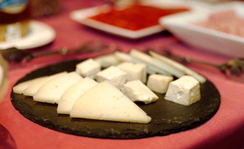 a plate of cheese on top of a table at Hotel Rua Villar in Santiago de Compostela