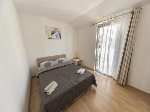 een slaapkamer met een bed en een groot raam bij Apartments Katoro Relax in Umag