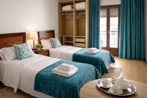 a hotel room with two beds and a table at Gav Remedios 20 in Ronda
