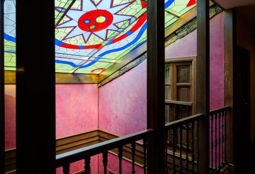 a stained glass window in a room with a balcony at Hotel Rua Villar in Santiago de Compostela