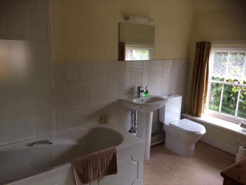 uma casa de banho com uma banheira, um lavatório e um WC. em Chalk Farm LDC em Eastbourne