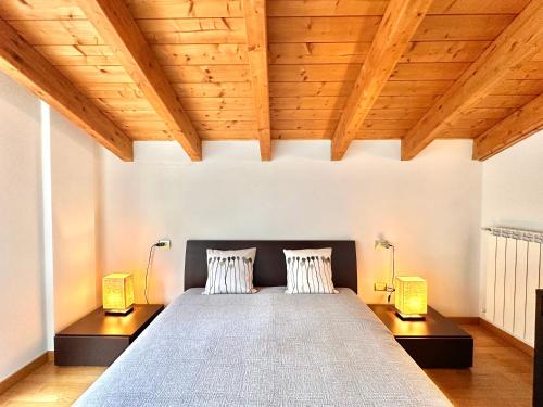 a bedroom with a large bed with two lamps at Terrazza fra lago e monti in Gravedona