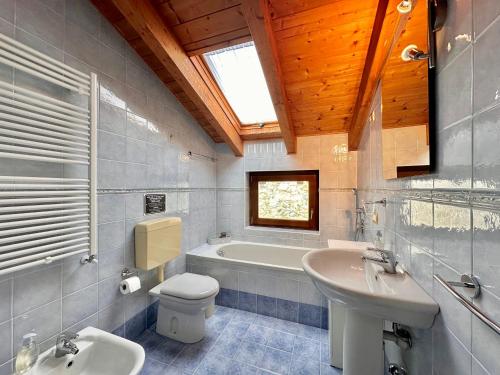 a bathroom with a toilet and a sink and a tub at Terrazza fra lago e monti in Gravedona