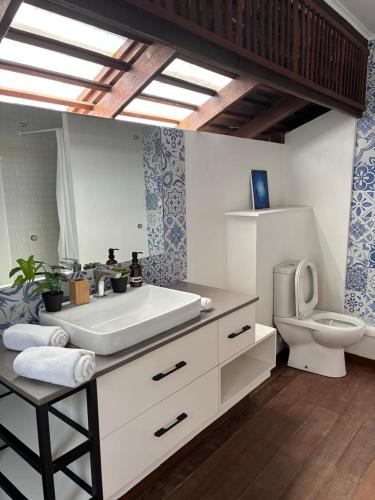 a bathroom with a white sink and a toilet at KAZ DIBWA Beach House in Glacis