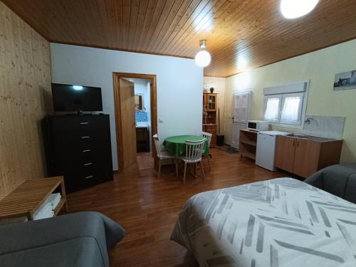 a room with a bed and a table and a kitchen at Habitación independiente en Casa Rural Javier in Valmuel