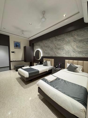 a hotel room with two beds and a flat screen tv at Hotel Govind Regency in Dhule