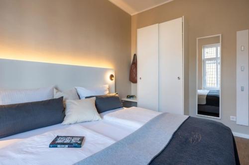 a bedroom with a large bed with a book on it at Woge2 Appartement 7 in Borkum