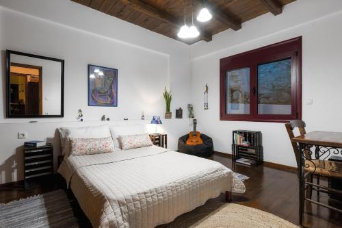 a bedroom with a bed and a table and a desk at The Retreat in Ierapetra