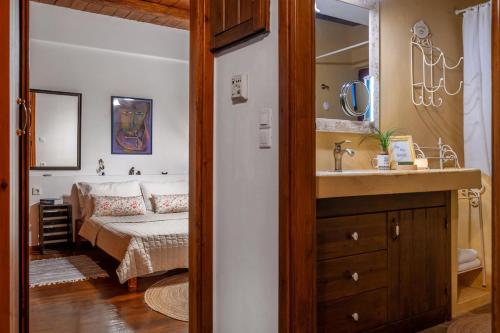 a bedroom with a bed and a sink and a mirror at The Retreat in Ierapetra
