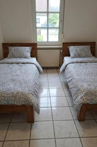 a bedroom with two beds and a window at Monteurwohnung Monti 1 in Saarbrücken
