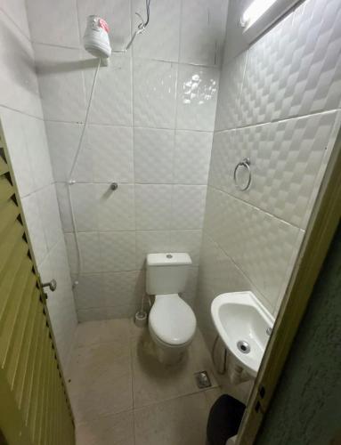 a small bathroom with a toilet and a sink at kit net master simple in Divinópolis