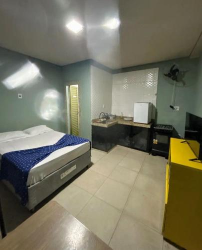 a bedroom with a bed and a sink in it at kit net master simple in Divinópolis
