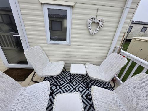 a patio with chairs and a heart wreath on a house at CASALIE at Seasalter Whitstable in Seasalter