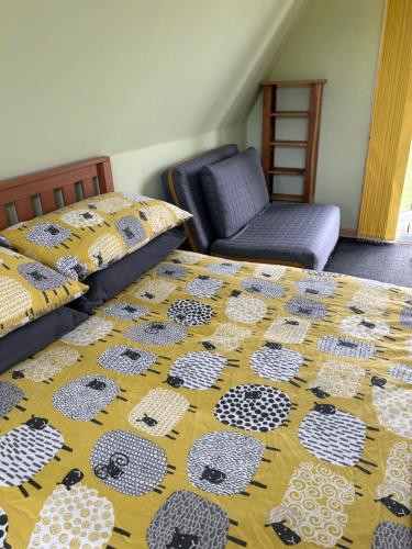 a bedroom with two twin beds and a chair at Sterlochy Cabin in Lochcarron