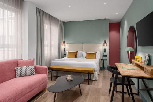 a hotel room with a bed and a couch at Tribu Malasaña in Madrid