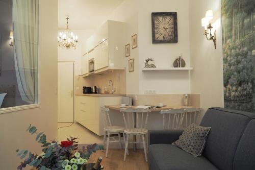 un salon avec un canapé et une table dans une cuisine dans l'établissement Louvre Opera Design ChicSuites, à Paris